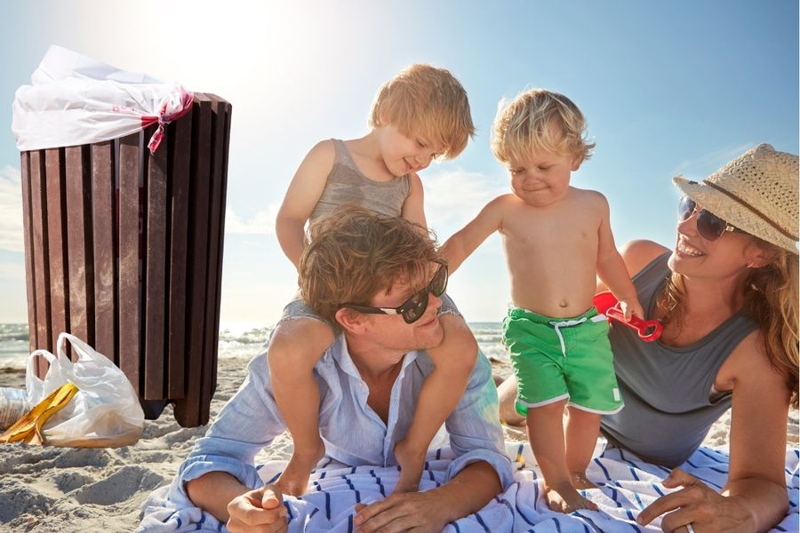 picturesque family at beach next to garbage can and trash