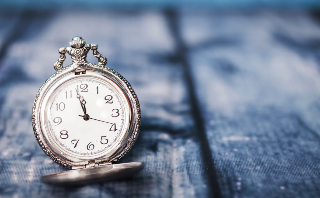 silver pocket watch on blue background