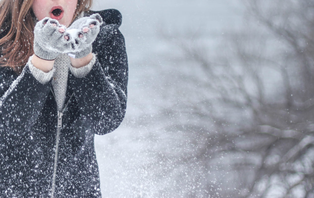 girl blowing snow off hands