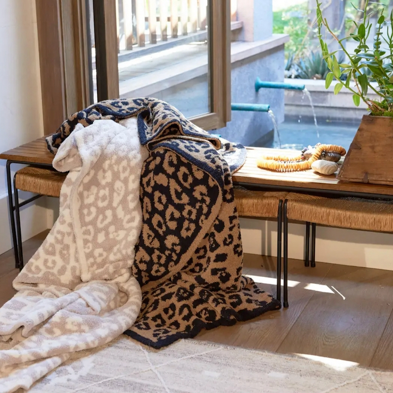 photo of two leopard blankets draped over an elegant bench