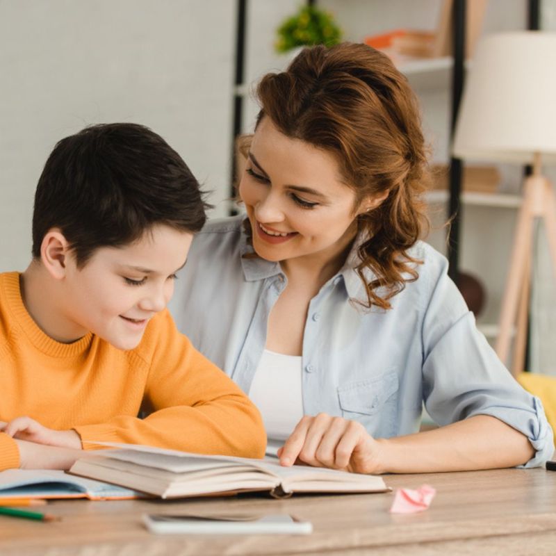 mother in chambray shirt helping son with homework