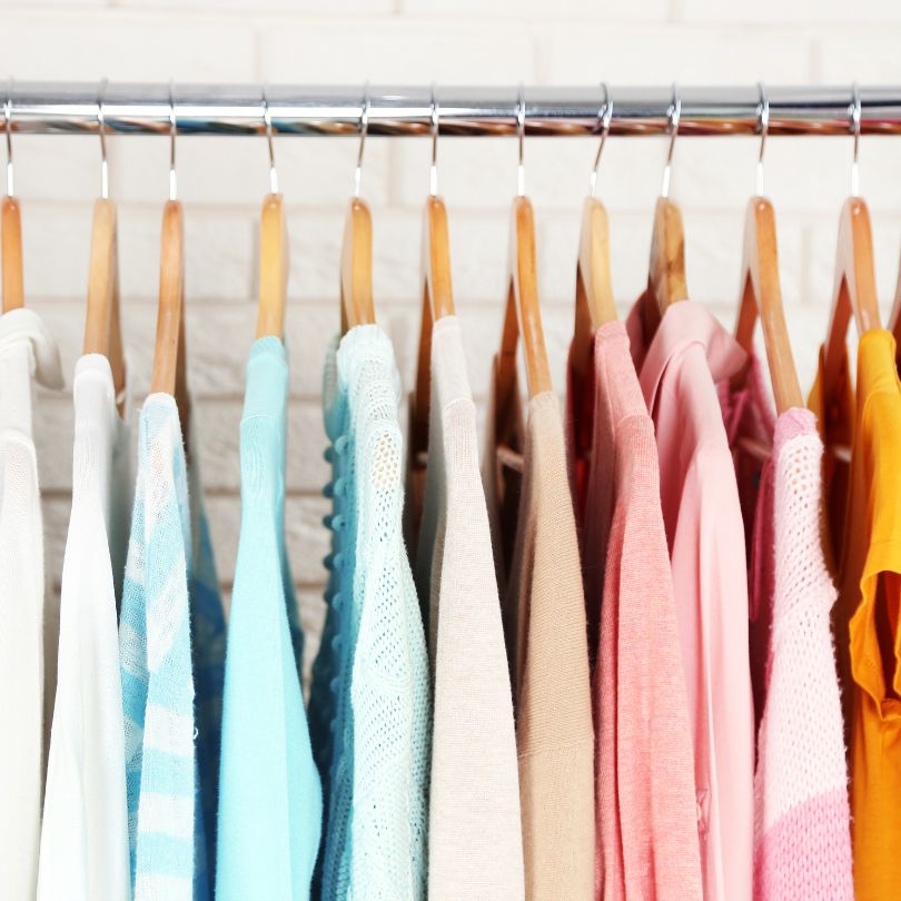 pastel colored clothes hanging in a row