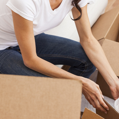 The Edit woman packing clothes into boxes