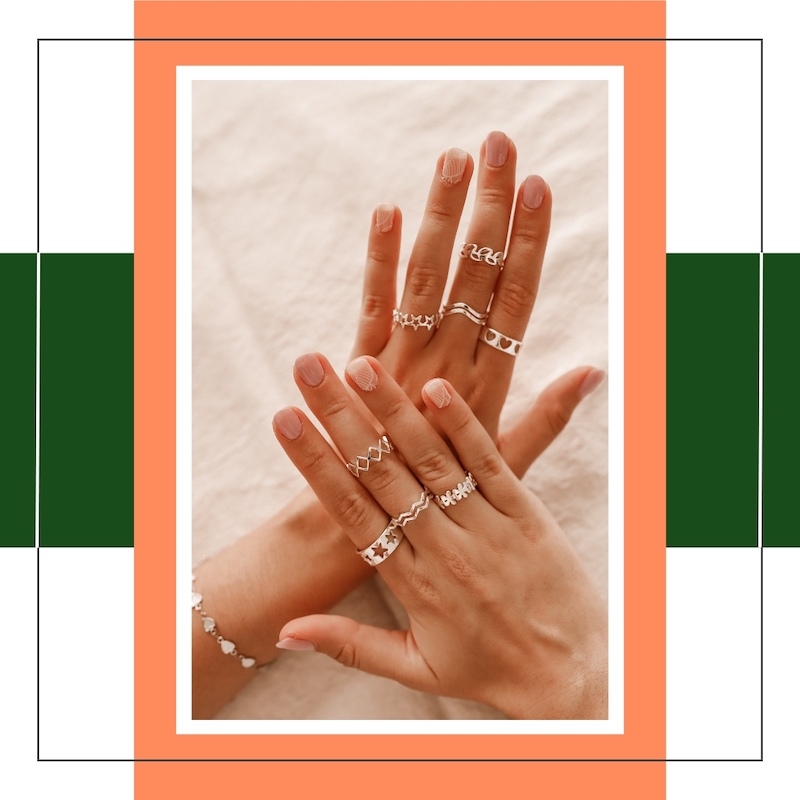 woman's hands wearing multiple silver rings