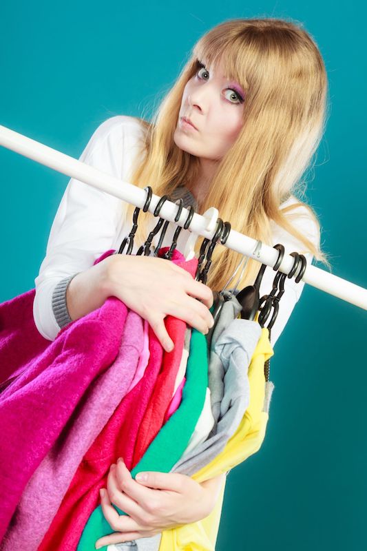 woman with threatening look on her face grabs and protects her favorite hanging clothes