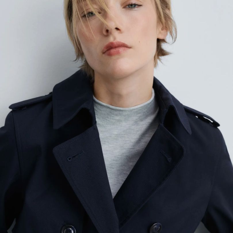 woman wearing beautifully fitted navy trench coat