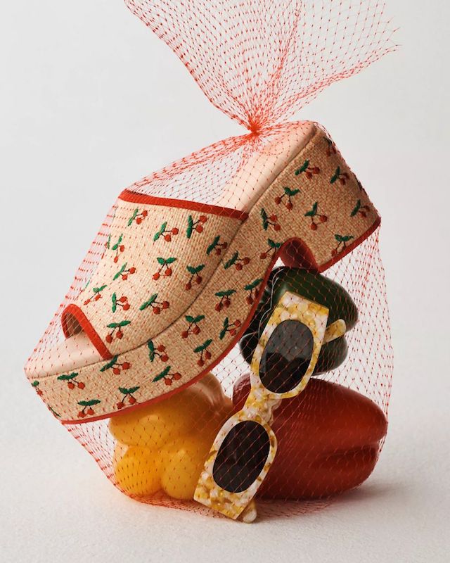 cherry patterned slide bagged in mesh with peppers and sunglasses